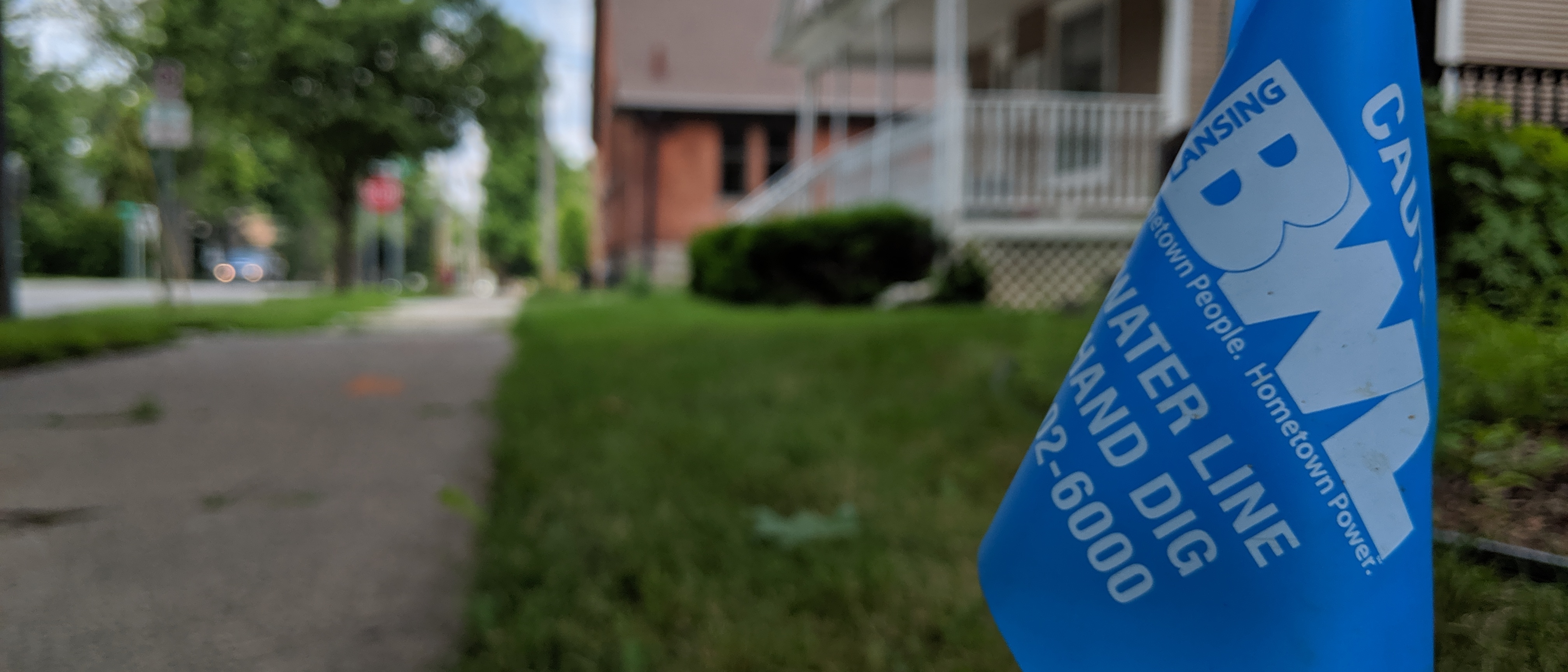 A blue utility flag sticks in the ground